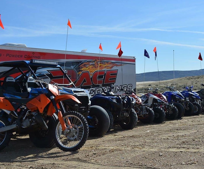 Race Coatings trailer and a row of race vehicles at an outdoor track